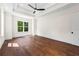 This main bedroom provides hardwood floors, trey ceiling, ceiling fan, and view of outdoors at 10350 Alvin Rd, Johns Creek, GA 30022