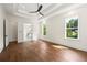 Large primary bedroom boasts hardwood floors, trey ceiling, fan, and entry to the primary bath at 10350 Alvin Rd, Johns Creek, GA 30022