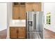Modern stainless steel refrigerator with wood cabinets and a view to the outdoors, a perfect kitchen detail at 10350 Alvin Rd, Johns Creek, GA 30022