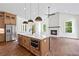 Open-concept kitchen features stainless steel appliances and island with pendant lighting at 10350 Alvin Rd, Johns Creek, GA 30022