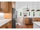 Open kitchen featuring an island with a sink, modern stainless steel appliances, fireplace, and wood floors at 10350 Alvin Rd, Johns Creek, GA 30022