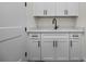 Modern laundry room featuring quartz countertop, white cabinets and stainless steel hardware at 10350 Alvin Rd, Johns Creek, GA 30022