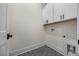 Simple laundry room featuring overhead cabinets and dark grey, hexagonal tiled floors at 10350 Alvin Rd, Johns Creek, GA 30022