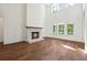 Inviting living room with hardwood floors, fireplace, and large windows showcasing backyard at 10350 Alvin Rd, Johns Creek, GA 30022