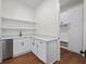 This mudroom features a sleek beverage fridge, open shelving, lockers, and wood floors for easy cleanup at 10350 Alvin Rd, Johns Creek, GA 30022