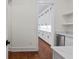 A beautiful pantry with ample storage space, white cabinets, wood floors, and a beverage refrigerator at 10350 Alvin Rd, Johns Creek, GA 30022