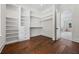 Large walk-in closet featuring custom shelves, drawers, hanging racks and hardwood floors at 10350 Alvin Rd, Johns Creek, GA 30022