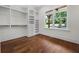 Large walk-in closet featuring custom shelves, drawers, hanging racks, hardwood floors and window at 10350 Alvin Rd, Johns Creek, GA 30022