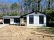 Charming exterior view of a renovated home with white painted brick, black trim, a new porch and garage at 2400 Glenrock Dr, Decatur, GA 30032