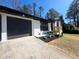 Close up of the exterior highlighting the home's new dark painted garage door, black trim, and wood porch at 2400 Glenrock Dr, Decatur, GA 30032
