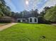 Charming renovated home with a freshly painted white brick exterior, dark trim, and a well-maintained green lawn at 2400 Glenrock Dr, Decatur, GA 30032