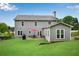A well-maintained backyard featuring a gray home with an outdoor patio set and lush green grass at 260 Roberts Rd, Suwanee, GA 30024