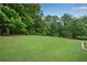Lush green backyard with mature trees, offering shade and a serene, private outdoor space at 260 Roberts Rd, Suwanee, GA 30024