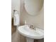 Neutral powder room with pedestal sink and decorative mirror at 260 Roberts Rd, Suwanee, GA 30024