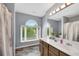 Bathroom features a spacious vanity, decorative mirrors, and large windows offering view of lush outdoors at 260 Roberts Rd, Suwanee, GA 30024