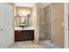 Bright bathroom with tiled shower, dark wood vanity, and decorative mirror at 260 Roberts Rd, Suwanee, GA 30024