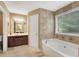 Bathroom featuring a soaking tub, tile flooring, and dark wood cabinets at 260 Roberts Rd, Suwanee, GA 30024