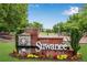 Welcome to Suwanee sign with decorative flowers, brick, stone, and a manicured lawn at 260 Roberts Rd, Suwanee, GA 30024