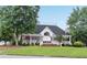 A beautiful clubhouse with a porch, American flag, and well-manicured lawn at 260 Roberts Rd, Suwanee, GA 30024