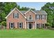 Beautiful brick home with a manicured lawn and symmetrical window design at 260 Roberts Rd, Suwanee, GA 30024