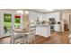 Charming kitchen features white cabinets, stainless appliances, and eat in dining area at 260 Roberts Rd, Suwanee, GA 30024