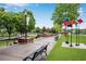 Benches and unique art installations on a public green space with mature trees at 260 Roberts Rd, Suwanee, GA 30024
