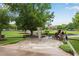 Town green with sundial sculpture, stone walkways, landscaped gardens, and shade trees at 260 Roberts Rd, Suwanee, GA 30024