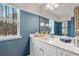 Elegant bathroom with white cabinets, quartz countertop, and views of the wooded outdoors from a window at 520 Amethyst Way, Stockbridge, GA 30281