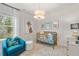 Charming Bedroom with white wainscoting, a gold crib, and a cozy blue armchair by the window at 520 Amethyst Way, Stockbridge, GA 30281