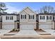 Stylish townhouse showcasing a two-car garage, complementary brick, and well-maintained front lawn at 520 Amethyst Way, Stockbridge, GA 30281