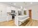 Bright kitchen with white cabinets, stainless appliances, and island with bar stool seating and pendant lighting at 520 Amethyst Way, Stockbridge, GA 30281