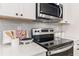 Modern kitchen features a stainless steel range and microwave and sleek white countertops and cabinetry at 520 Amethyst Way, Stockbridge, GA 30281