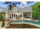 Luxurious backyard with a stone-accented pool, comfortable lounge furniture, and a covered outdoor seating area at 8957 Old Southwick Pass, Johns Creek, GA 30022