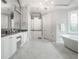 Elegant bathroom featuring marble flooring, a soaking tub, and custom cabinetry for a spa-like experience at 8957 Old Southwick Pass, Johns Creek, GA 30022