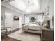 A spacious bedroom with a tray ceiling, light-colored walls, and a large bed with plush pillows at 8957 Old Southwick Pass, Johns Creek, GA 30022