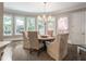 Elegant dining room with a round table, chandelier, and views of the outdoor landscape at 8957 Old Southwick Pass, Johns Creek, GA 30022