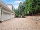 Expansive driveway with brick pavers leading to a three-car garage and basketball court at 8957 Old Southwick Pass, Johns Creek, GA 30022
