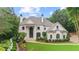 Elegant two-story home with white brick facade, black framed windows, and manicured landscaping at 8957 Old Southwick Pass, Johns Creek, GA 30022