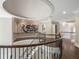 Elegant hallway featuring dark hardwood floors and an eye-catching wrought iron banister and ornate ceiling at 8957 Old Southwick Pass, Johns Creek, GA 30022
