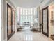 Grand living room featuring high ceilings, a wall of windows, an elegant chandelier, and marble floors at 8957 Old Southwick Pass, Johns Creek, GA 30022