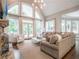 Bright living room with large windows, neutral decor, and a cozy seating area with fireplace at 8957 Old Southwick Pass, Johns Creek, GA 30022