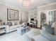 This living room has a stylish chandelier, elegant furniture, and plenty of natural light from the doorway at 8957 Old Southwick Pass, Johns Creek, GA 30022
