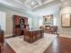 This office features a fireplace, hardwood floors, a coffered ceiling, and a large desk with hutch at 8957 Old Southwick Pass, Johns Creek, GA 30022