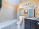 Well-lit bathroom with tiled walls, a vanity with mirror and a bathtub and shower combination at 904 Bridge Se Ln, Smyrna, GA 30082