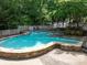Resort-style swimming pool surrounded by stone edging and mature trees, perfect for relaxation and recreation at 904 Bridge Se Ln, Smyrna, GA 30082