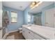 Well-lit bathroom with a vanity, full mirror, a shower and blue walls at 100 Gum Creek Lndg, Oxford, GA 30054