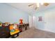 Bright bedroom featuring a ceiling fan, neutral carpet, and blue walls at 100 Gum Creek Lndg, Oxford, GA 30054