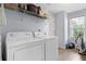 Laundry room featuring a washer, dryer, shelving, and a window at 100 Gum Creek Lndg, Oxford, GA 30054