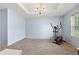 Bright living room featuring an elliptical machine, carpet, and a chandelier at 100 Gum Creek Lndg, Oxford, GA 30054