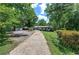 Long concrete driveway leads to a well-kept, single-story home surrounded by lush greenery and trees at 1095 Dallas Nebo Rd, Dallas, GA 30157